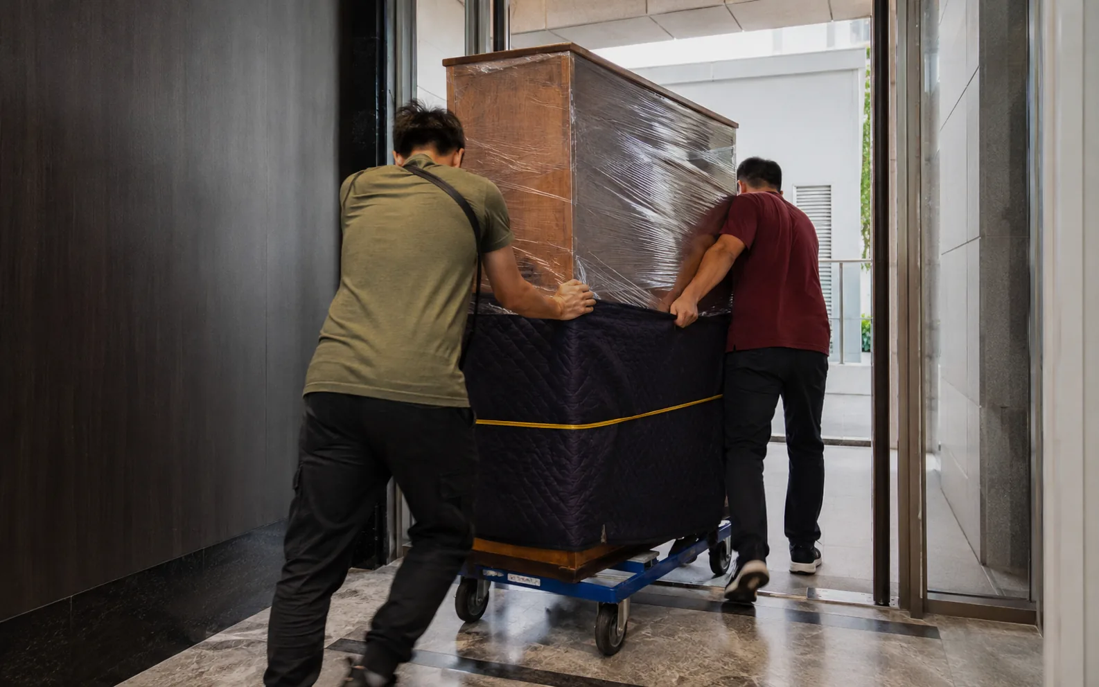 Movers handling a bulky item in Singapore.