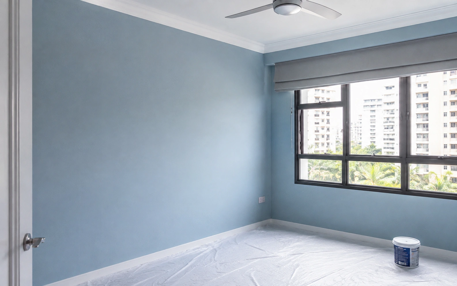Painter repainting a condo wall in Singapore.