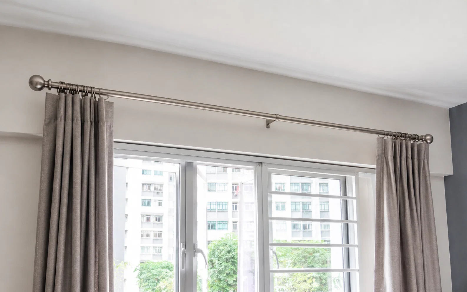 Installed curtain rod above a window in a Singapore home.