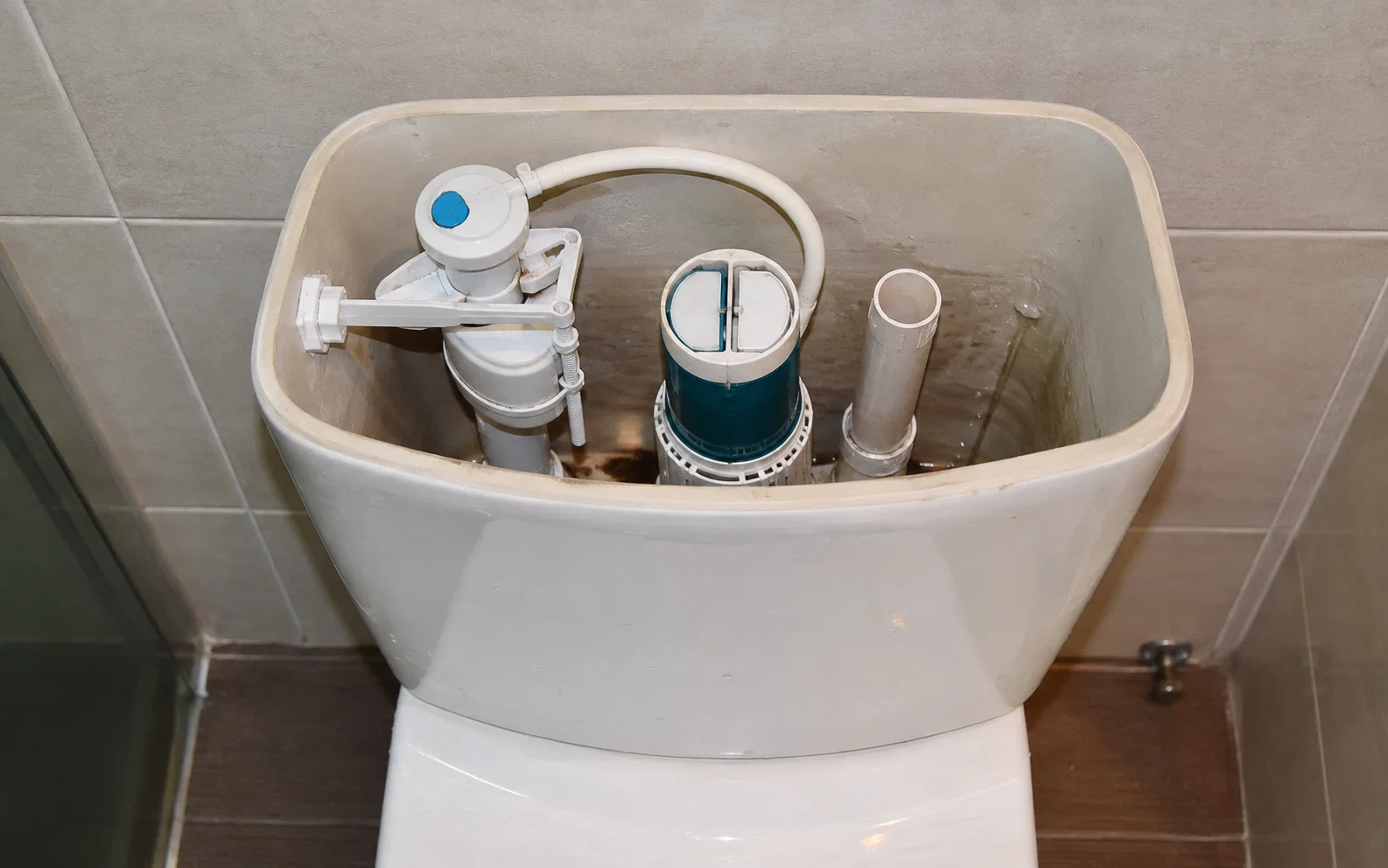 Toilet flush mechanism requiring repair in Singapore.